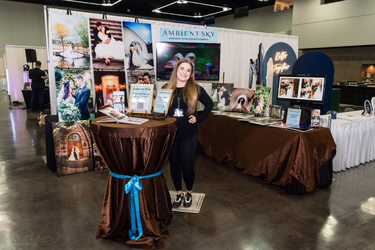 Ambient Sky Wedding Films and Photography displays wedding photos at their booth during the Portland Wedding Show with professional wedding photography samples and promotional materials