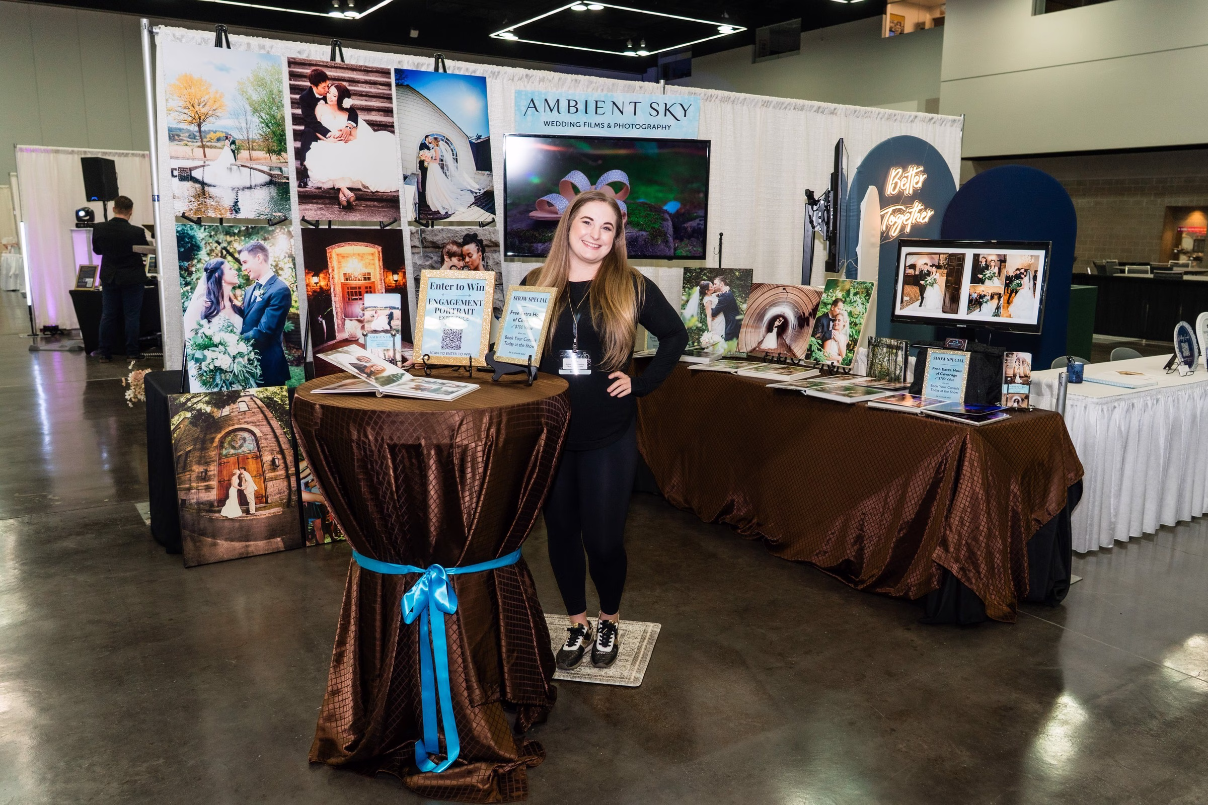Ambient Sky Wedding Films and Photography displays wedding photos at their booth during the Portland Wedding Show with professional wedding photography samples and promotional materials