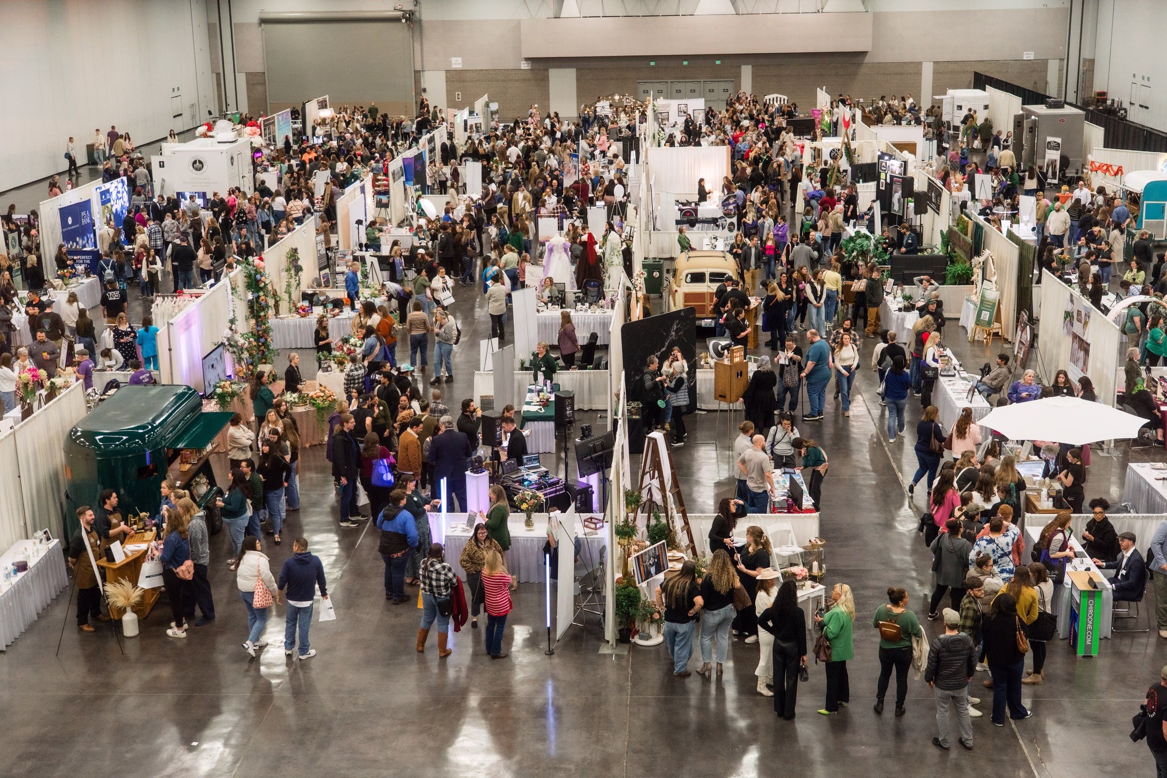 portland wedding show 2026 exhibition hall vendor booths - The Portland Wedding Show Aerial view of The Portland Wedding Show 2026 exhibition hall filled with wedding vendor booths and attendees browsing bridal services in Portland Oregon