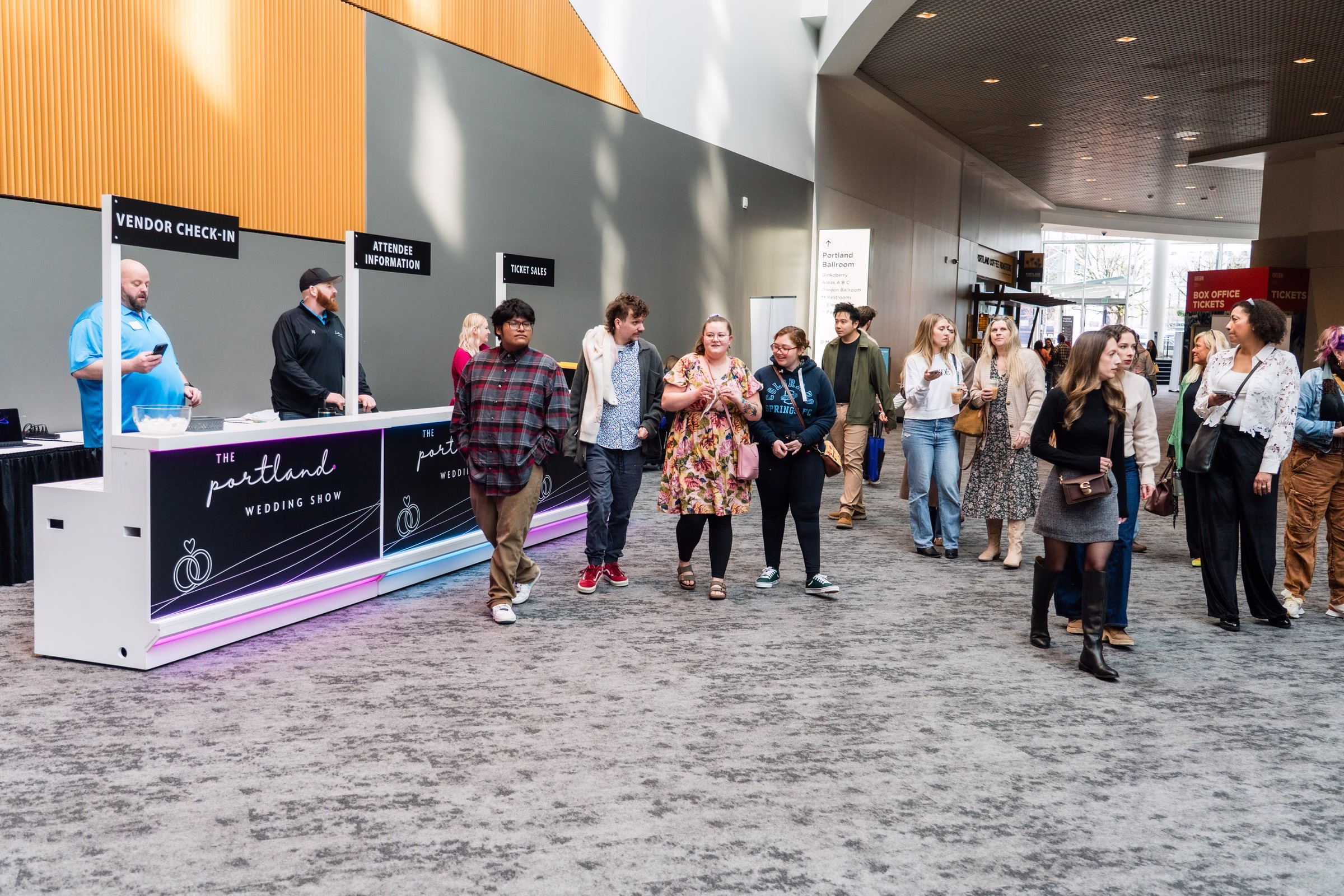 Attendees checking in at The Portland Wedding Show 2026 vendor registration area in modern convention center lobby